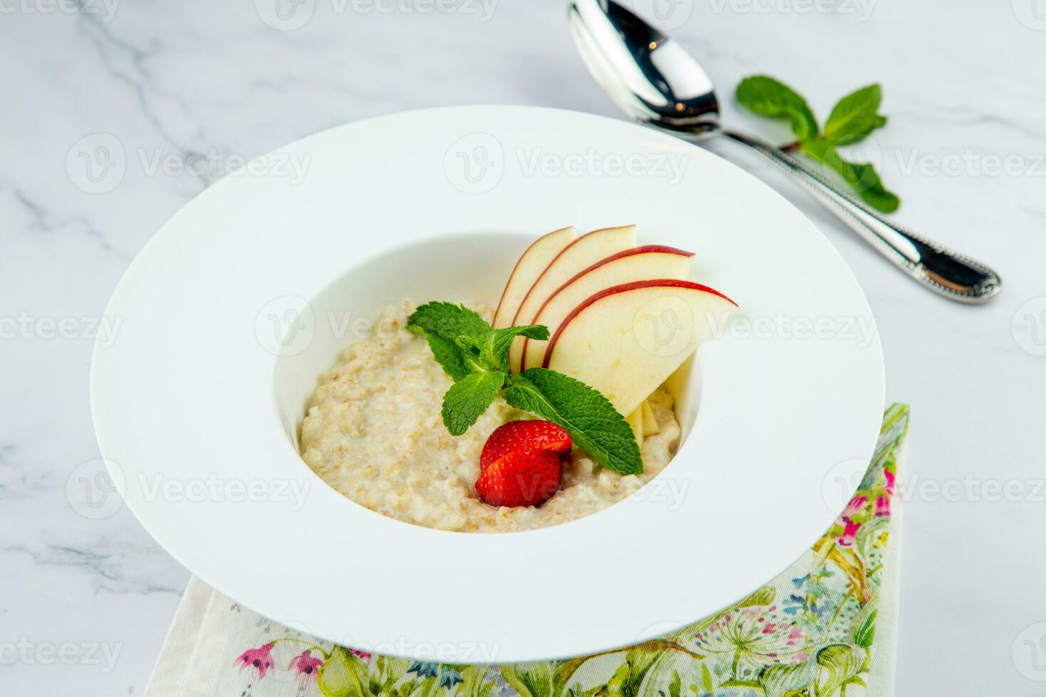 Apfel Haferbrei mit Minze und Erdbeeren im ein Weiß Platte, Seite Aussicht foto