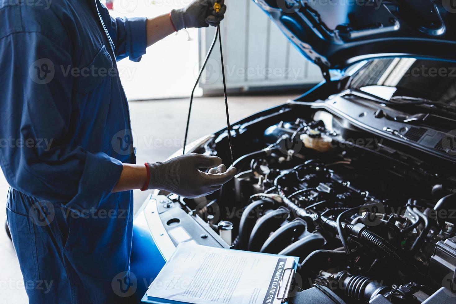 Automechaniker, der das Getriebeöl überprüft, um den Kundenanspruch zu warten foto