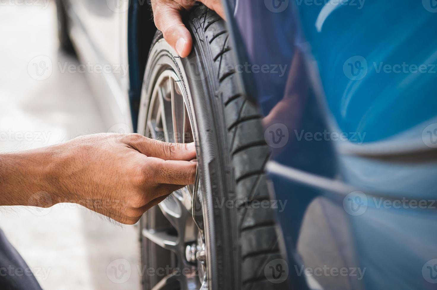 Nahaufnahme männlicher Kfz-Techniker, der Reifenventil-Stickstoffkappe entfernt? foto