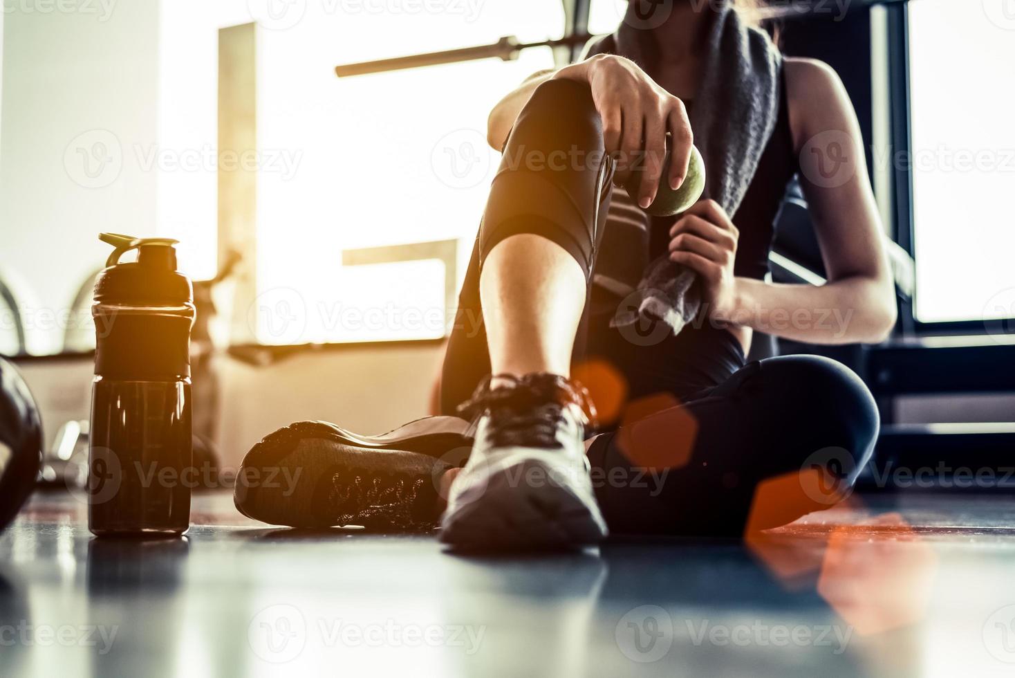 Sportfrau, die nach dem Training sitzt und ausruht foto