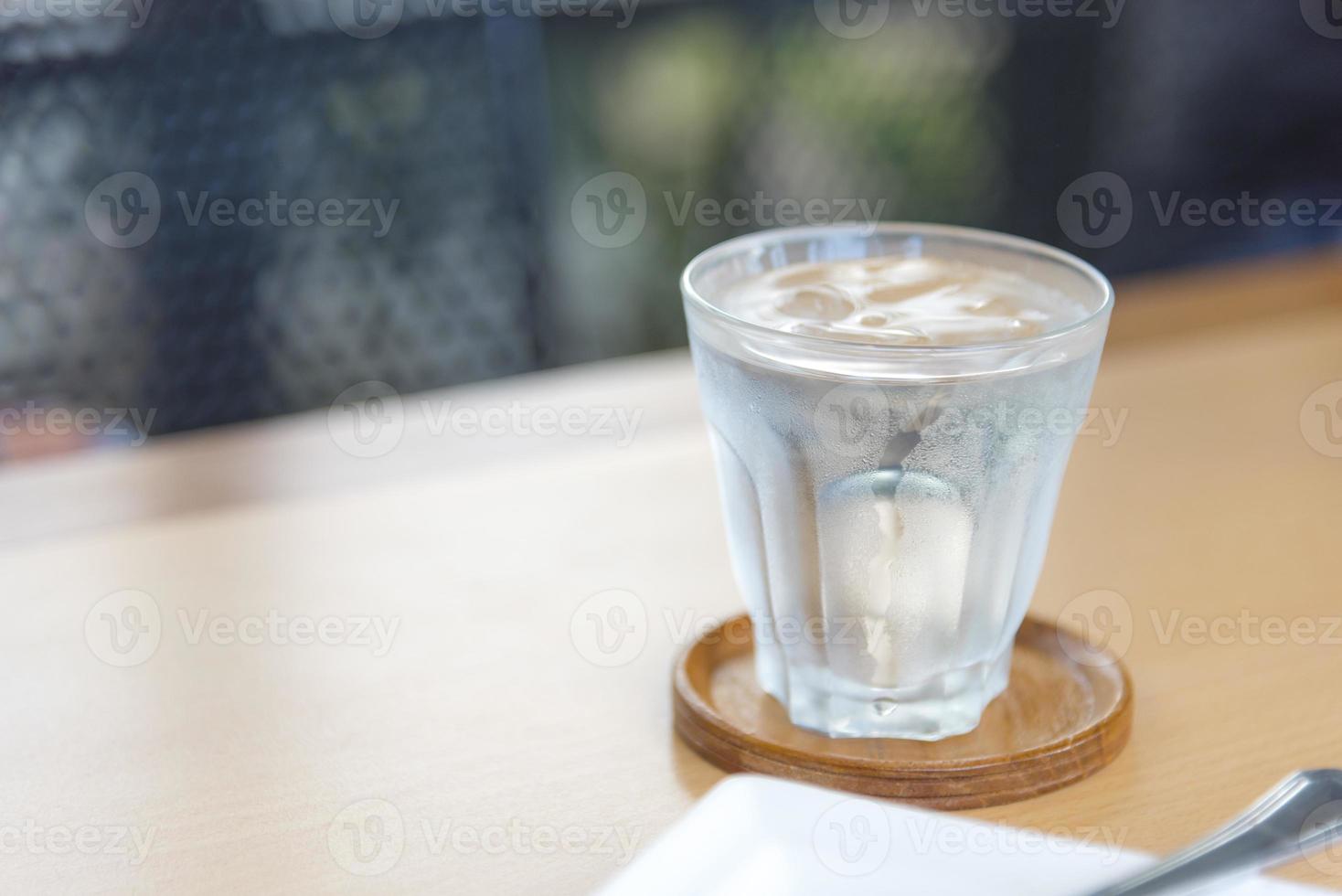 Mineralwasser im Glas auf Holztisch mit abstraktem Hintergrund foto