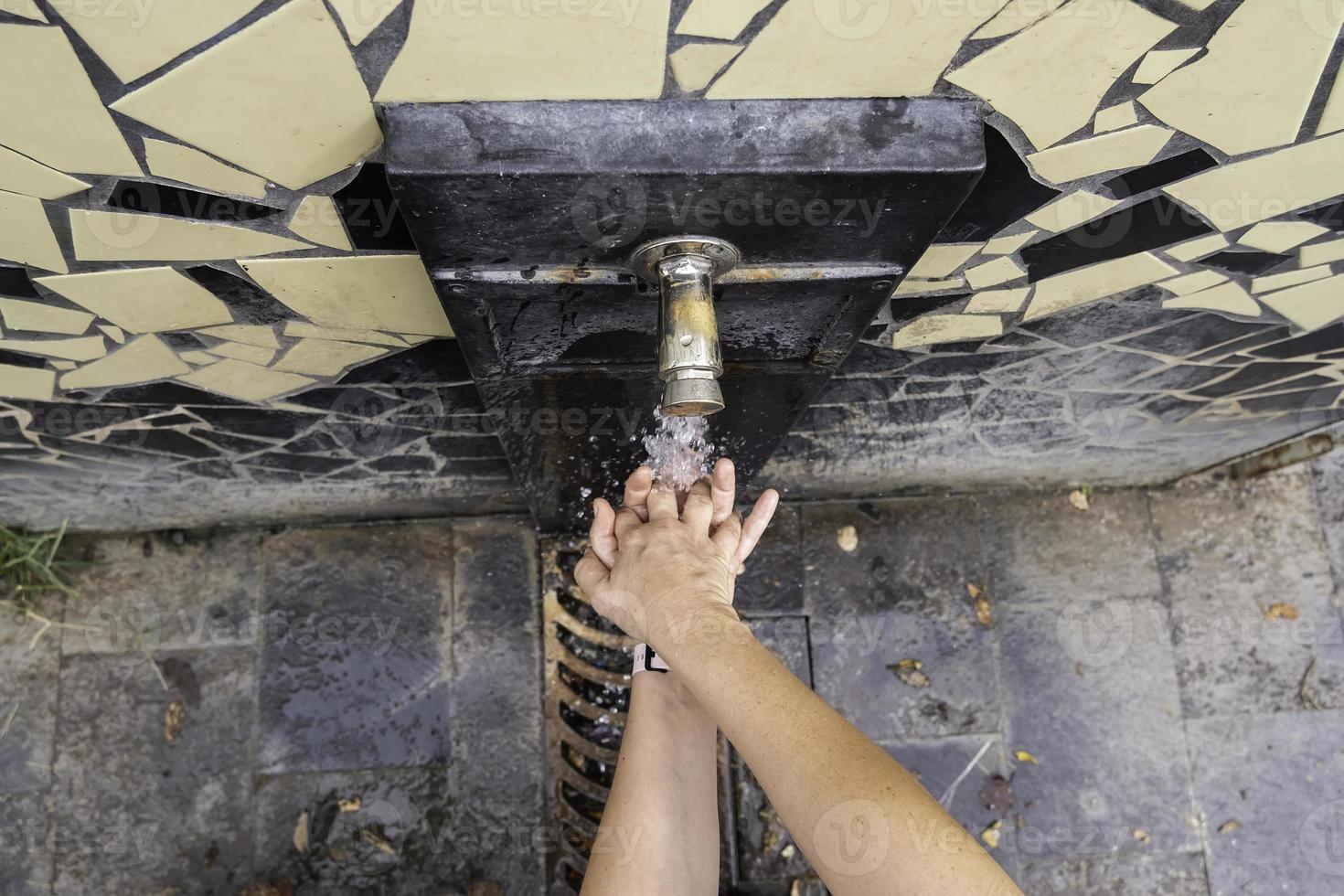 Händewaschen in einem Brunnen foto