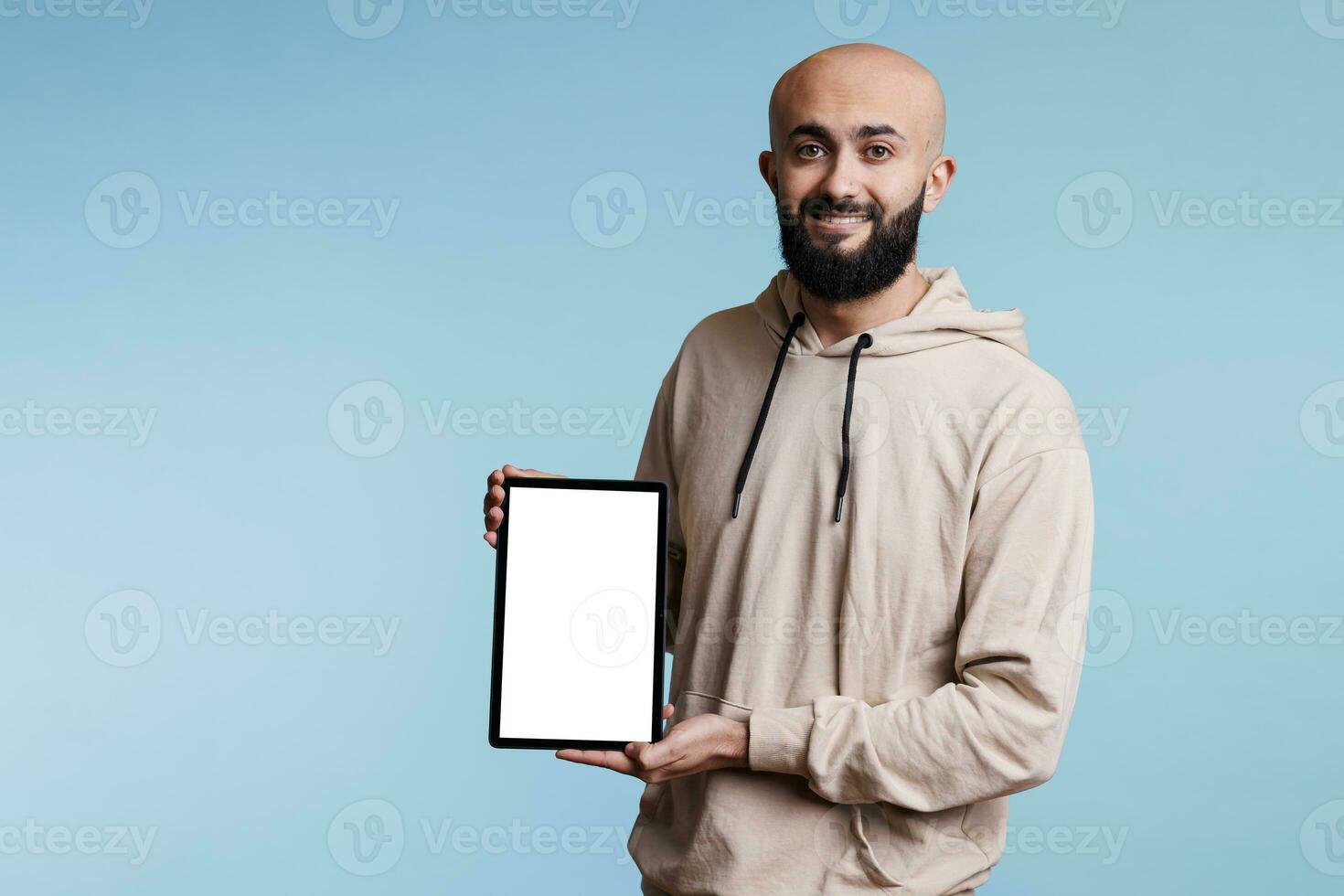 lächelnd arabisch Mann präsentieren Werbung auf Digital Tablette Weiß leer Bildschirm Porträt. heiter Person halten tragbar Gadget und zeigen spotten oben zum Software Anwendung Beförderung foto