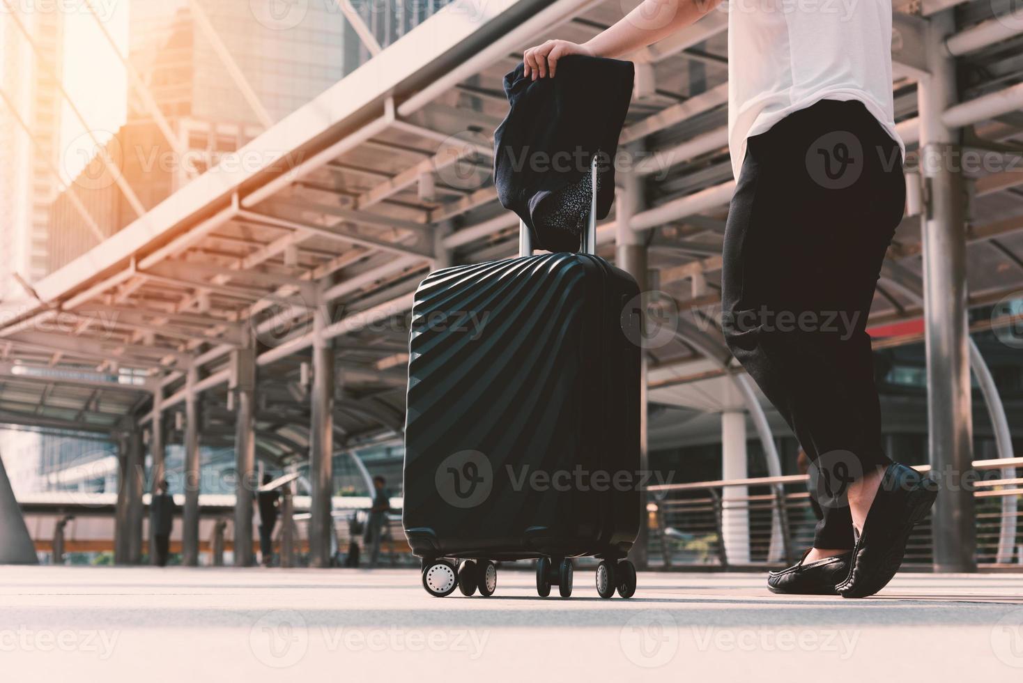 asiatische Frau, die mit Gepäck zum Flughafenterminal geht foto