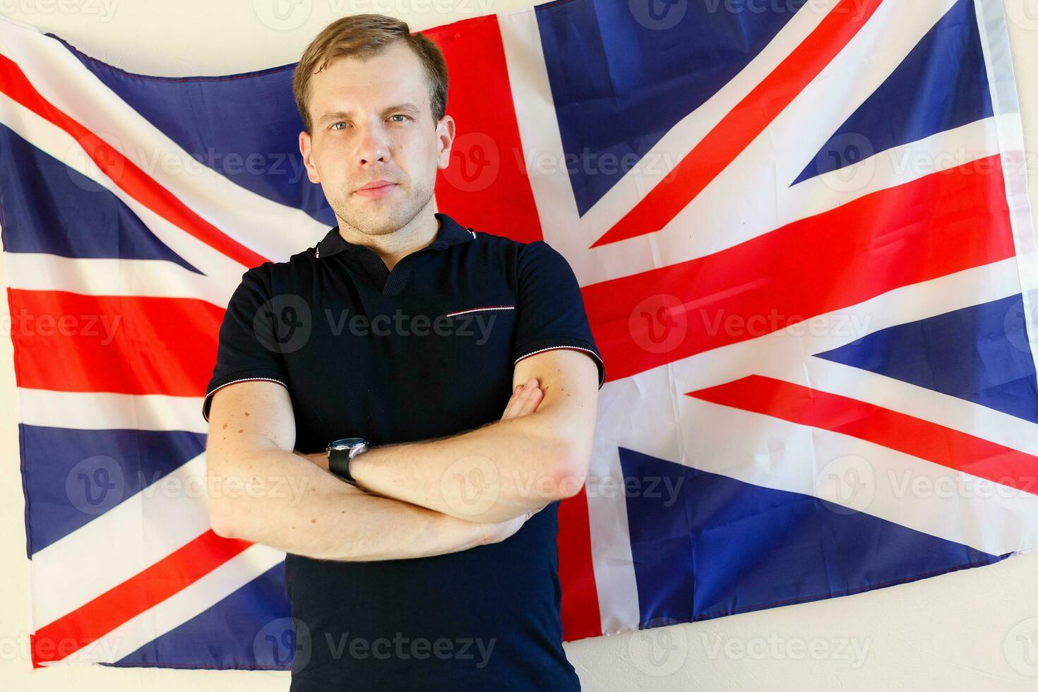 Porträt des jungen Mannes gegen britische Flagge foto