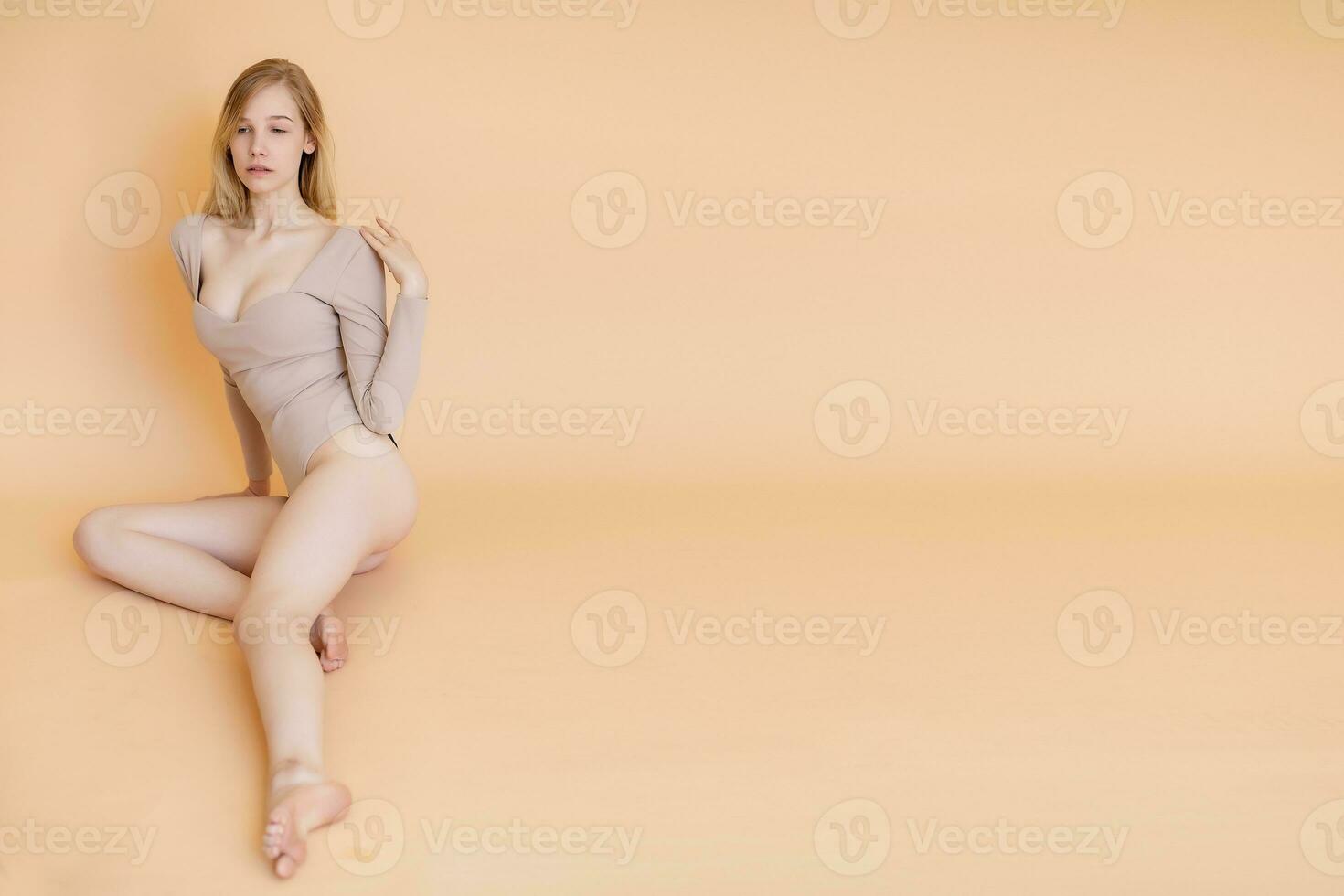Porträt von ein lächelnd jung blond Frau tragen Beige Badeanzug foto