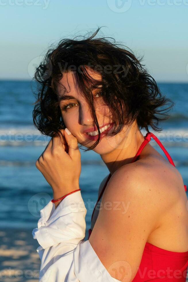 sexy zurück von ein schön Frau im rot Bikini auf Meer Hintergrund foto