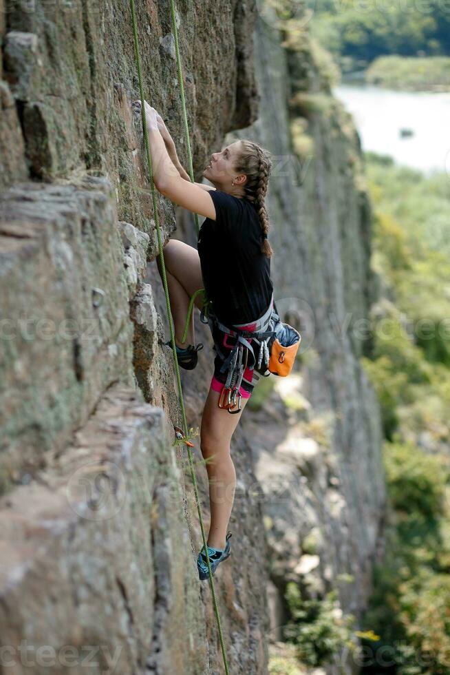 ein Mädchen klettert ein Felsen. Frau beschäftigt, verlobt im extrem Sport. foto