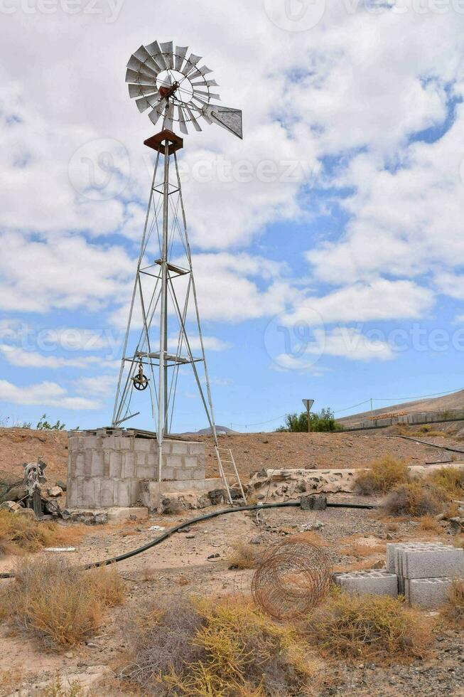 ein alt Windmühle im das Wüste mit ein Blau Himmel foto