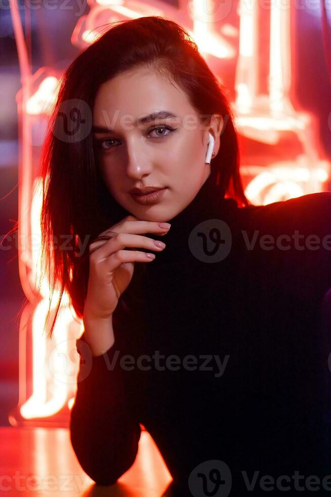 Porträt von ein Mädchen auf das Hintergrund von ein Neon- Zeichen von ein Geschäft Fenster foto