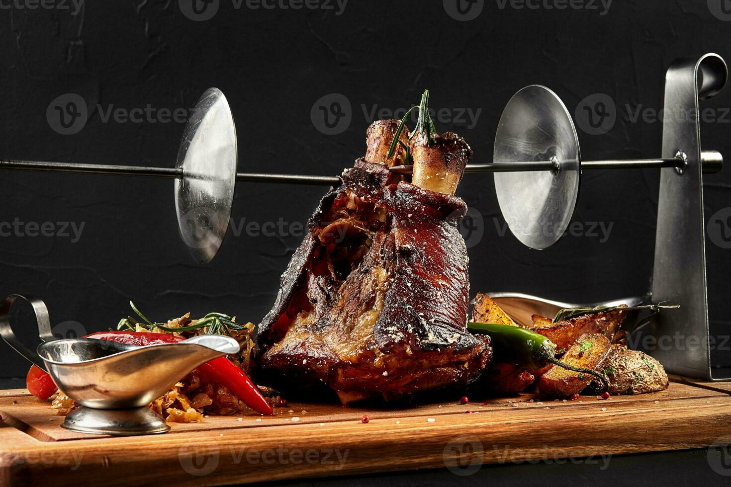 geröstet Schweinefleisch Knöchel Eisbein mit geschmort gekocht Kohl, Kartoffeln, Chili Pfeffer und Senf auf hölzern Schneiden Planke, auf ein schwarz Hintergrund foto