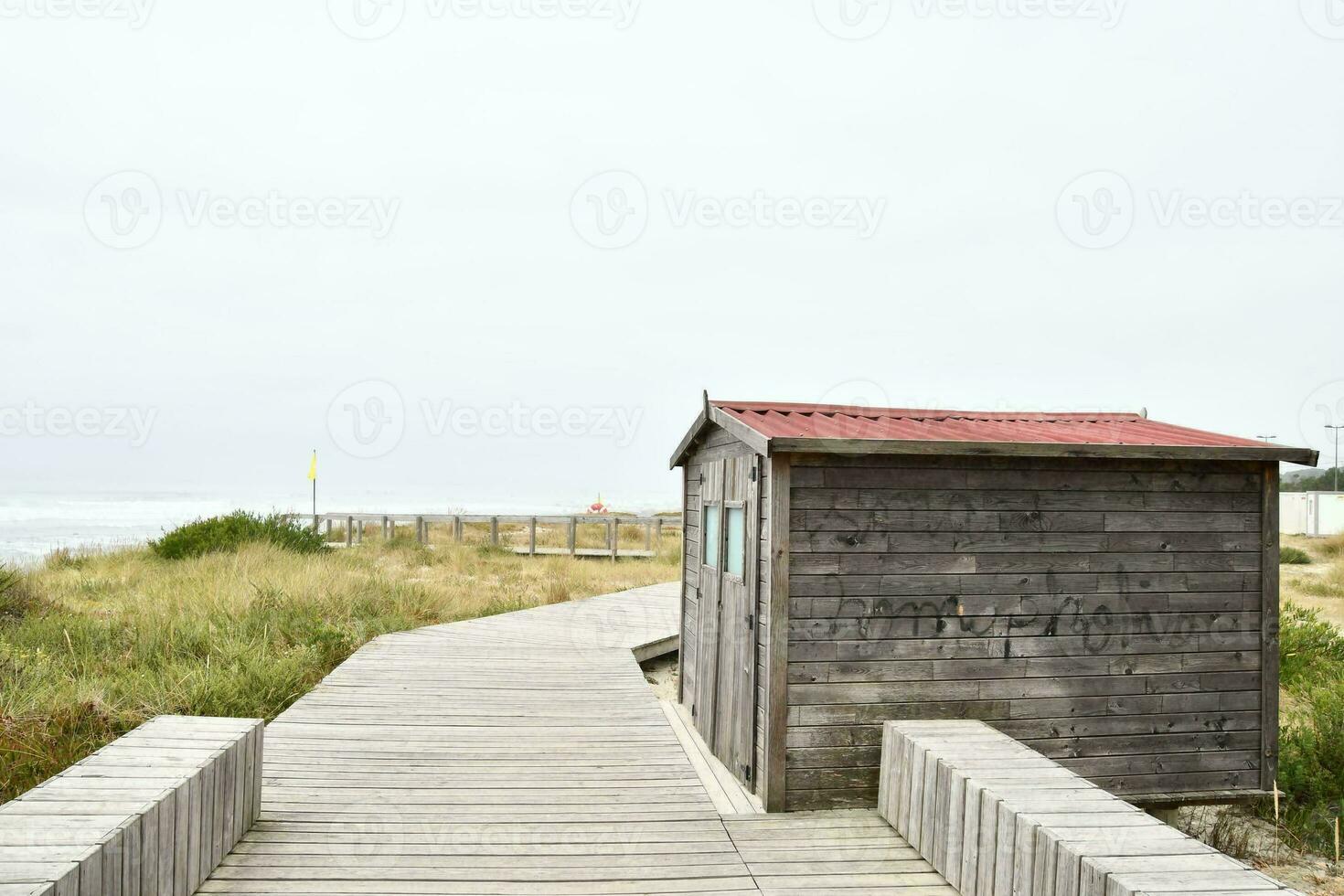 ein hölzern Gehweg führt zu ein Strand Hütte foto