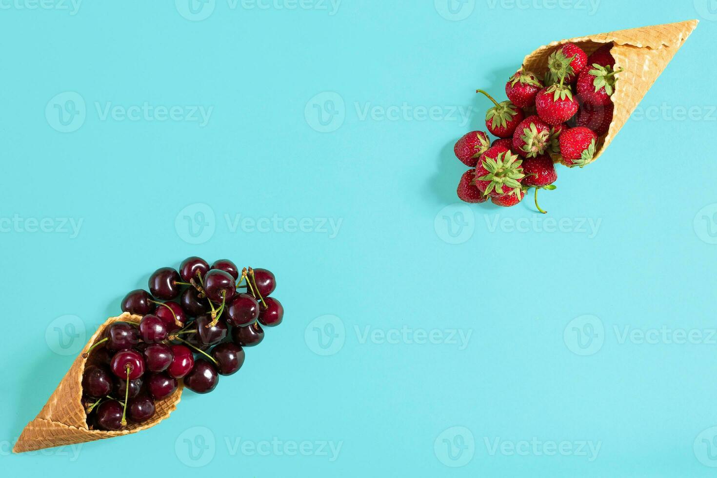 Beeren im Waffel Zapfen - - Erdbeere und schwarz Kirsche auf Blau ba foto