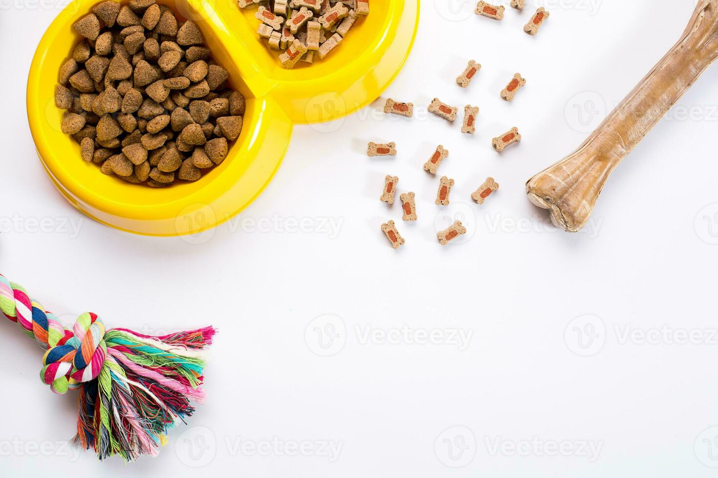 trocken Haustier Essen im Schüssel und Spielzeuge zum Hunde auf Weiß Hintergrund oben Aussicht foto