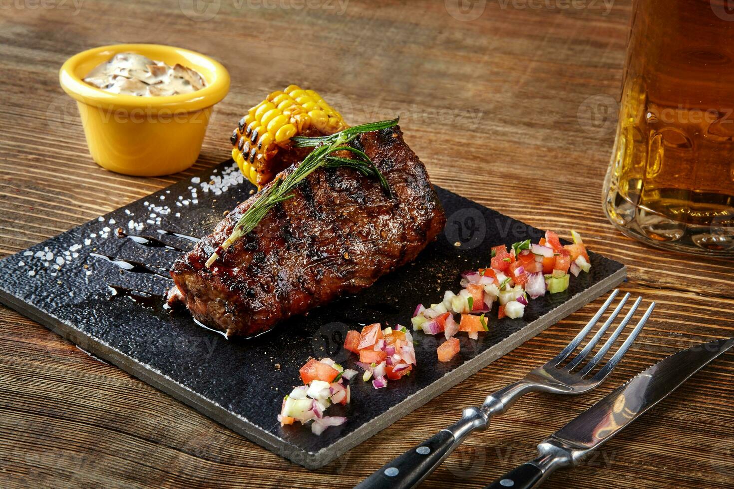 gegrillt Filet Steak Roastbeef und Pilze Soße auf schwarz Schneiden Tafel und Glas von Bier auf hölzern Hintergrund foto