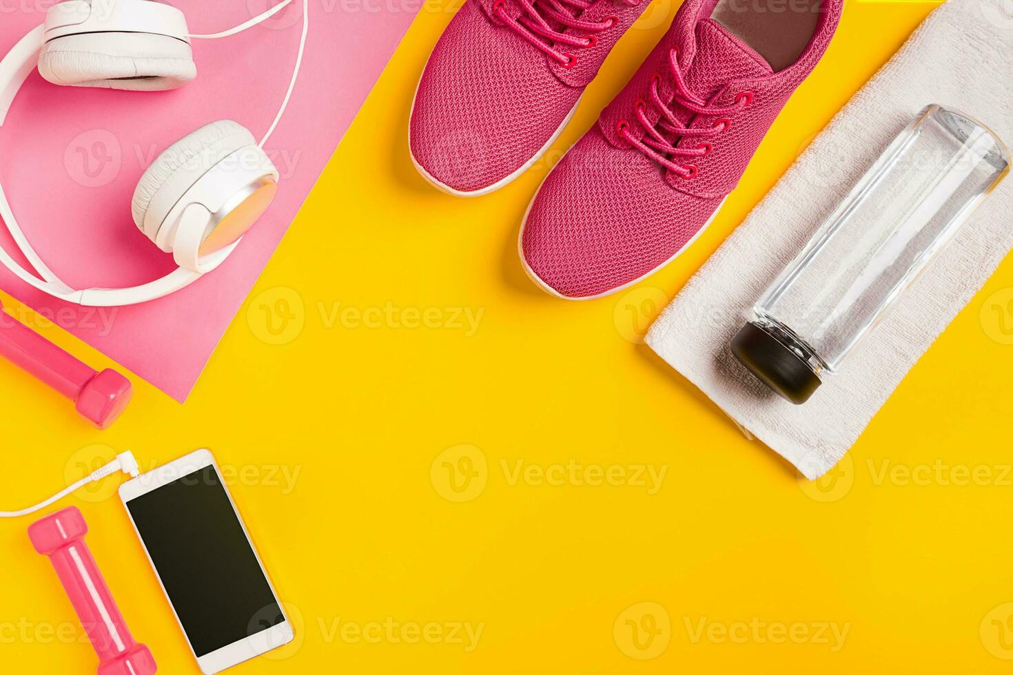 Fitness Zubehör auf ein Gelb Hintergrund. Turnschuhe, Flasche von Wasser, Kopfhörer und Hanteln. foto