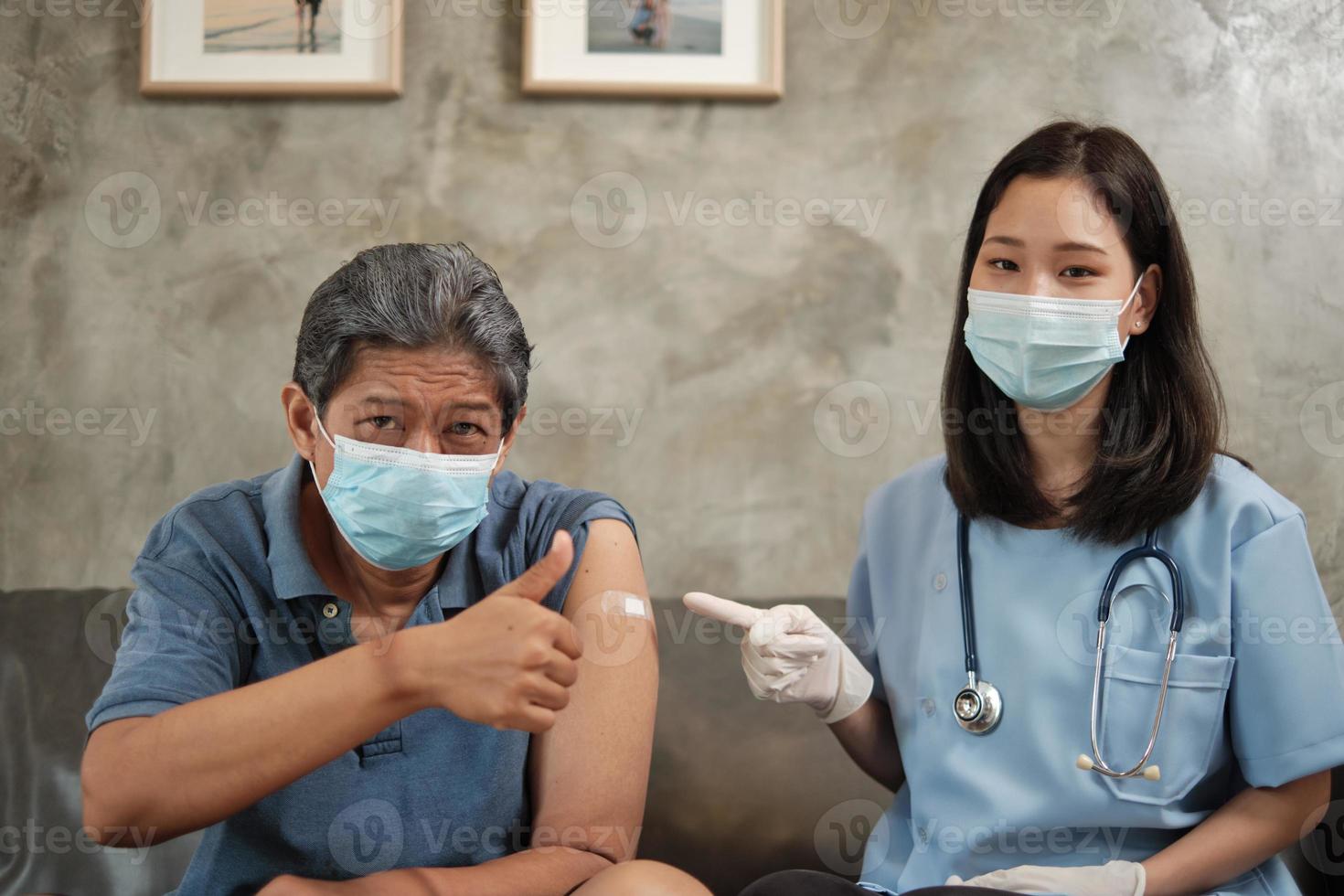 älterer patient mit gesichtsmaske daumen hoch, wenn geimpft. foto