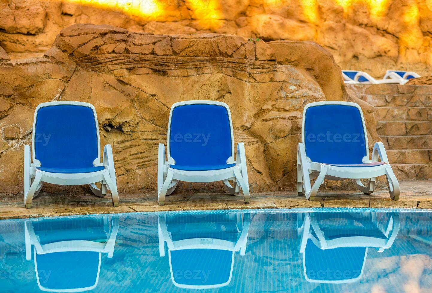 mehrere von Sonne Liegen durch ein schön Schwimmen Schwimmbad foto
