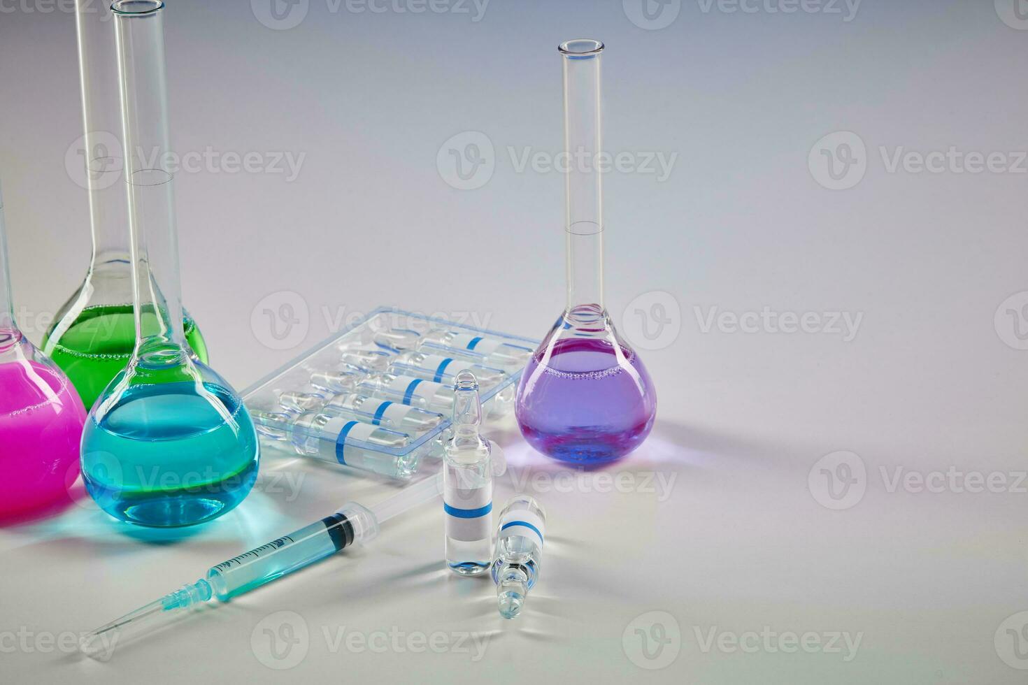 vier medizinisch Flaschen mit bunt chemisch Reagenzien. Sieben Attrappe, Lehrmodell, Simulation Ampullen mit transparent Flüssigkeit und Spritze isoliert auf Weiß. Coronavirus foto