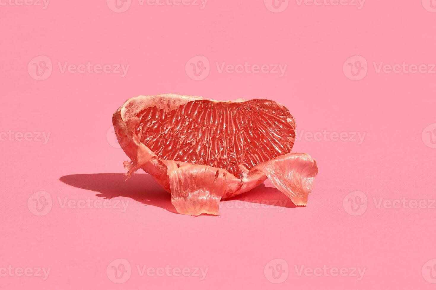 schließen oben hoch Qualität Bild von geschält Scheibe von saftig Grapefruit auf ein Rosa Hintergrund foto