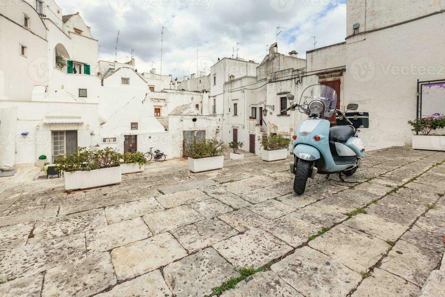 Aussicht von das alt Stadt, Dorf von Martina franca. klassisch Blau Moped auf das Hintergrund von ein alt Gebäude. foto