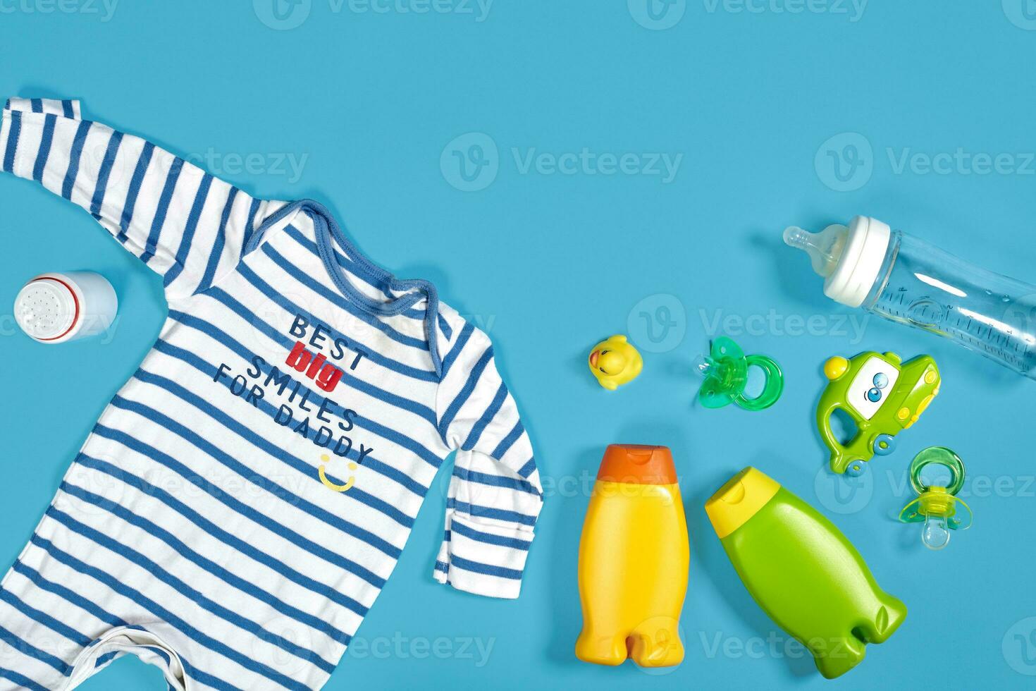 Baby Pflege mit Bad Satz. Nippel, Spielzeug, Kleidung, Shampoo auf Blau Hintergrund oben Aussicht Attrappe, Lehrmodell, Simulation foto