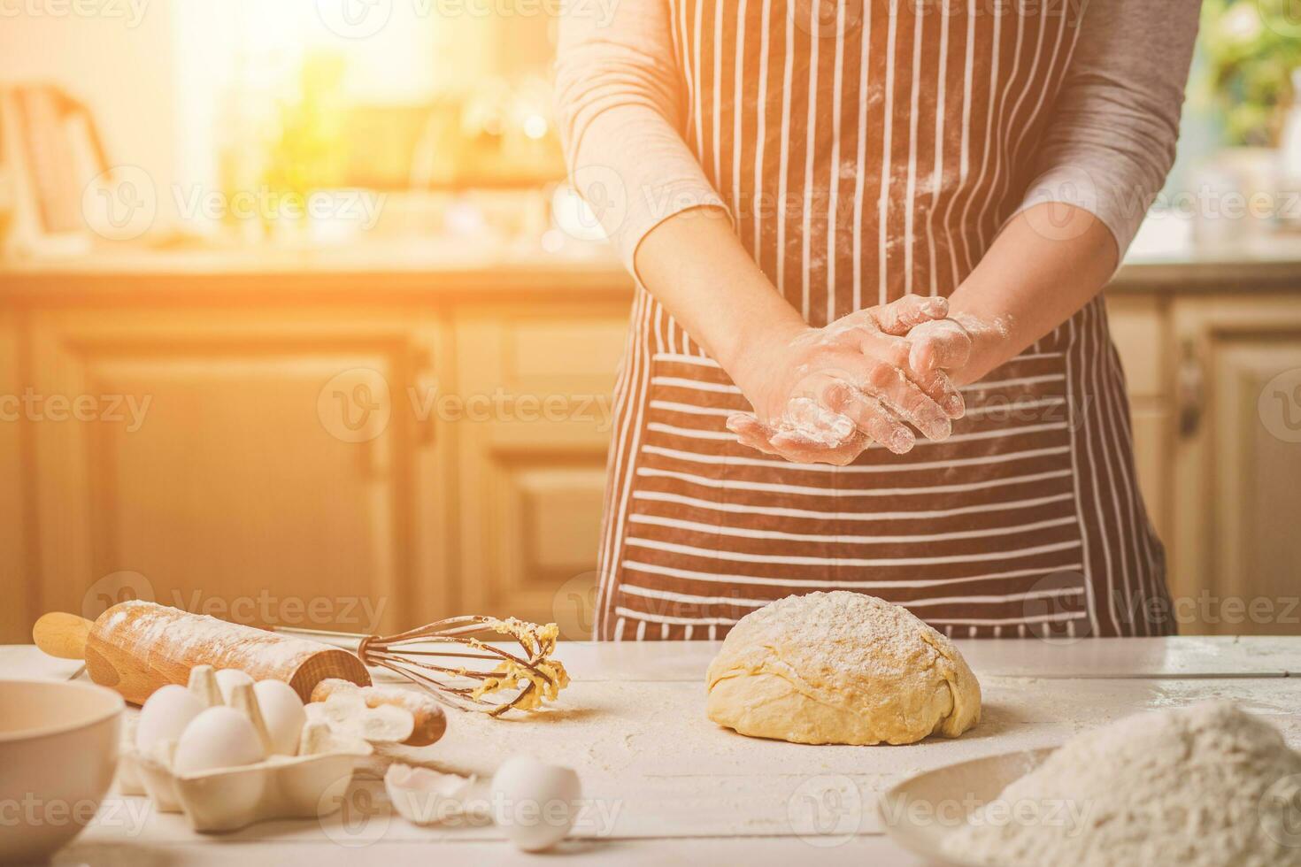 Frau schlagen seine Hände über Teig Nahaufnahme. Bäcker Fertigstellung seine Bäckerei, Shake Mehl von seine Hände, kostenlos Raum zum Text. foto