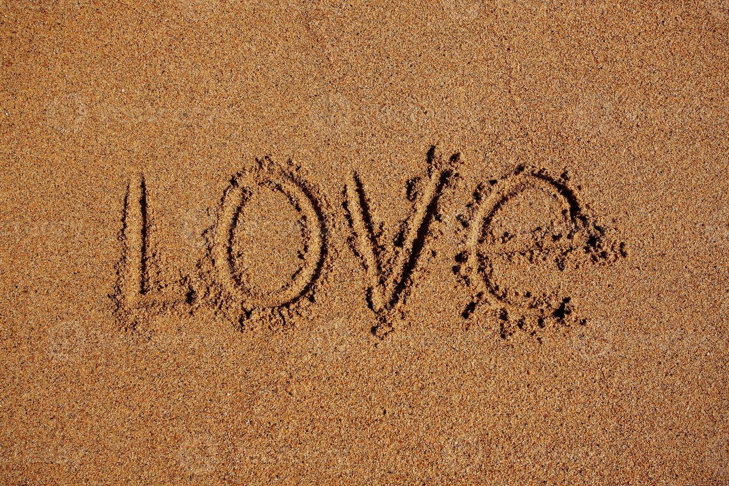 Wort Liebe in den Sand geschrieben foto