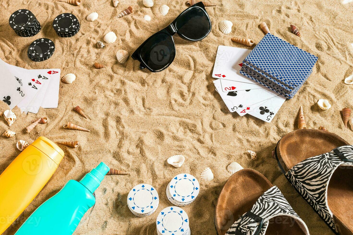 Strandpoker. Chips und Karten auf das Sand. um das Muscheln, Sonnenbrille und Flip Flops. oben Aussicht foto