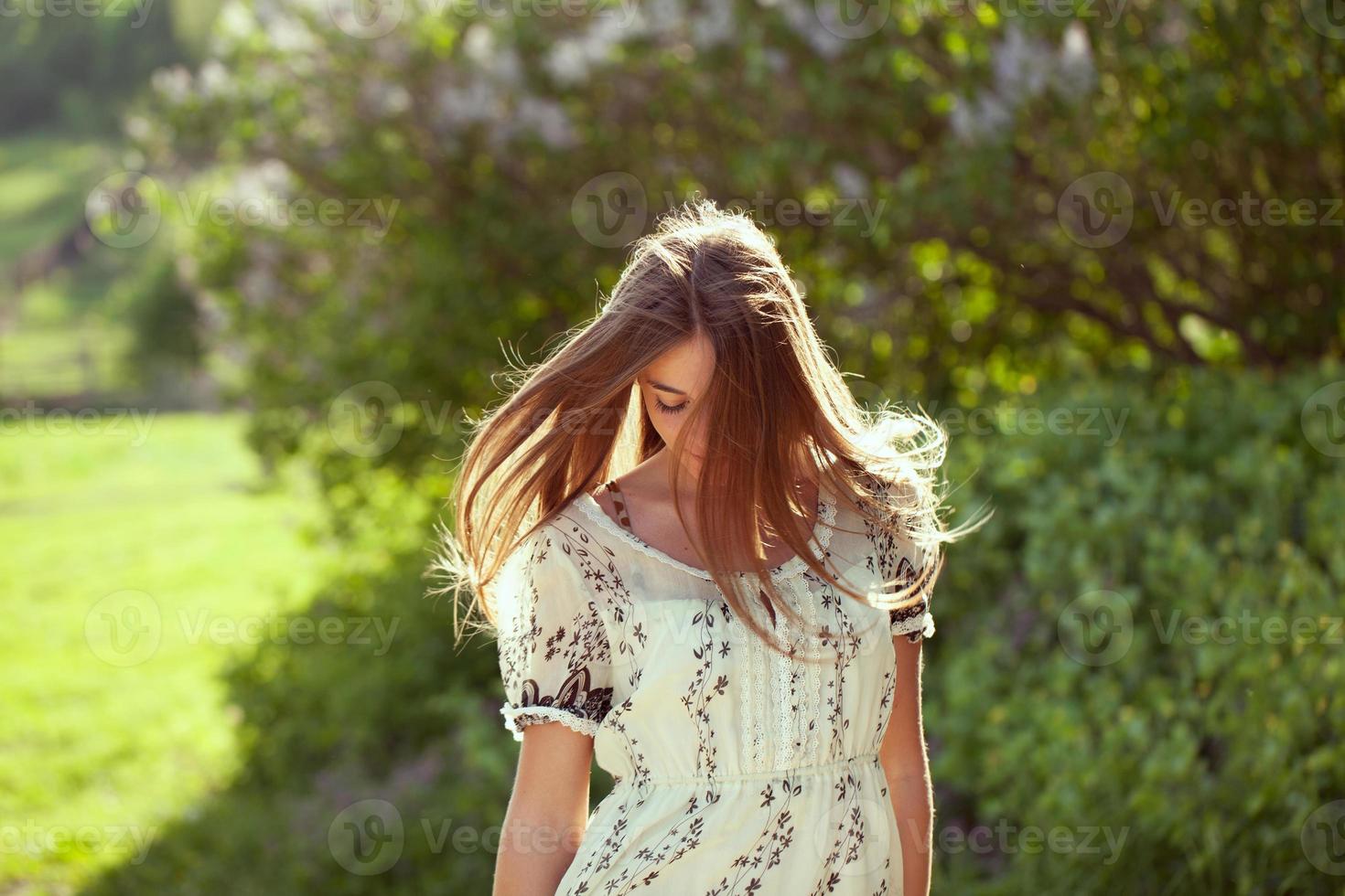 Mädchen in einem Sommerkleid mit langen Haaren foto