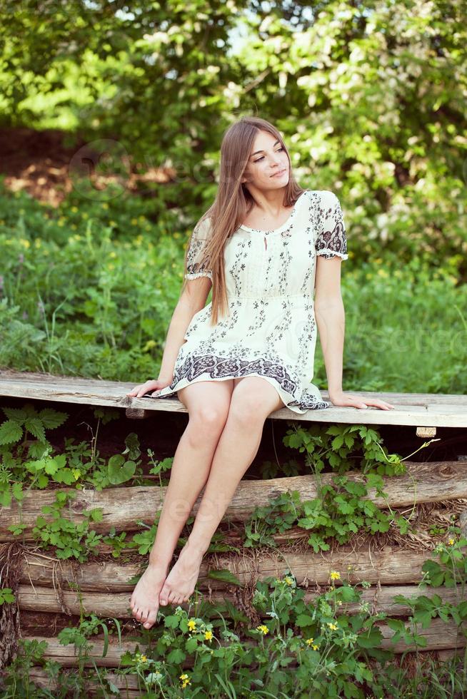 Mädchen in einem Sommerkleid sitzt und entspannt foto