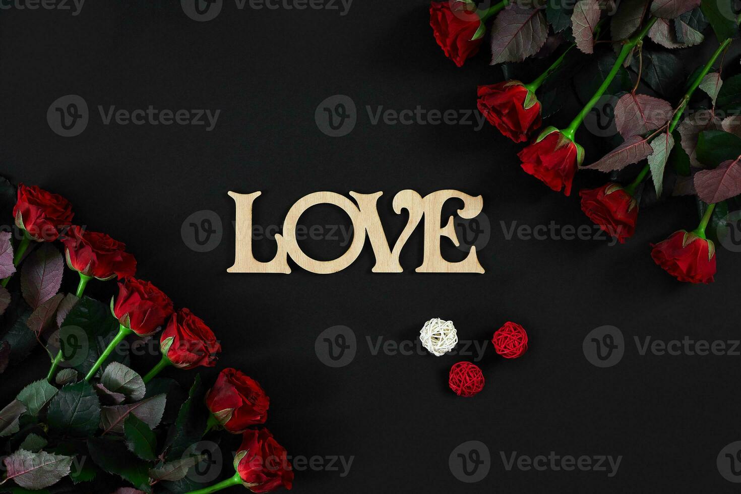 rot Rosen Blumen mit hölzern Wort Liebe auf schwarz Hintergrund mit foto