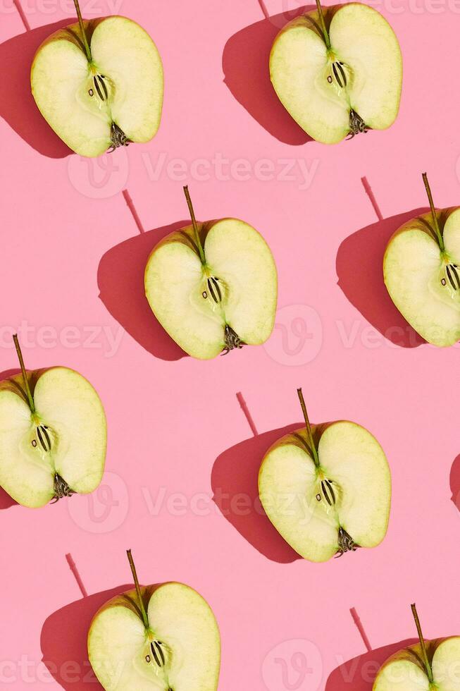 bunt Obst Muster von frisch geschnitten Apfel Hälften mit Gruben auf Koralle Rosa Hintergrund, oben Aussicht foto