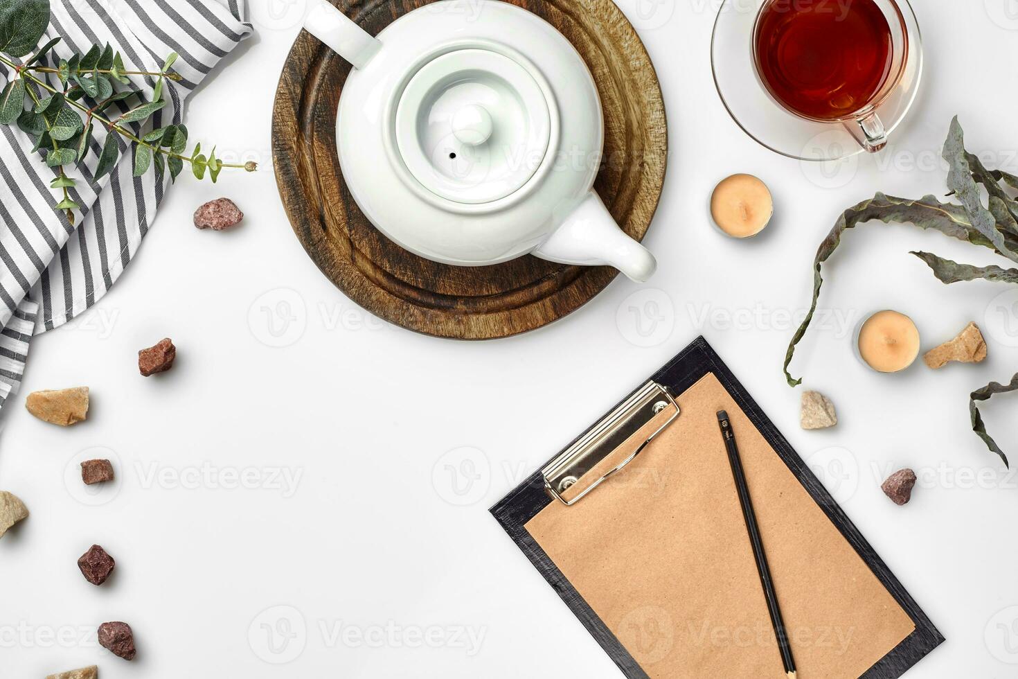 Weiß Hintergrund auf welche Kunst Papier, Notizbuch, Tasse mit Tee und Weiß Porzellan Teekanne. romantisch Frühstück. oben Sicht. Kopieren Raum. foto