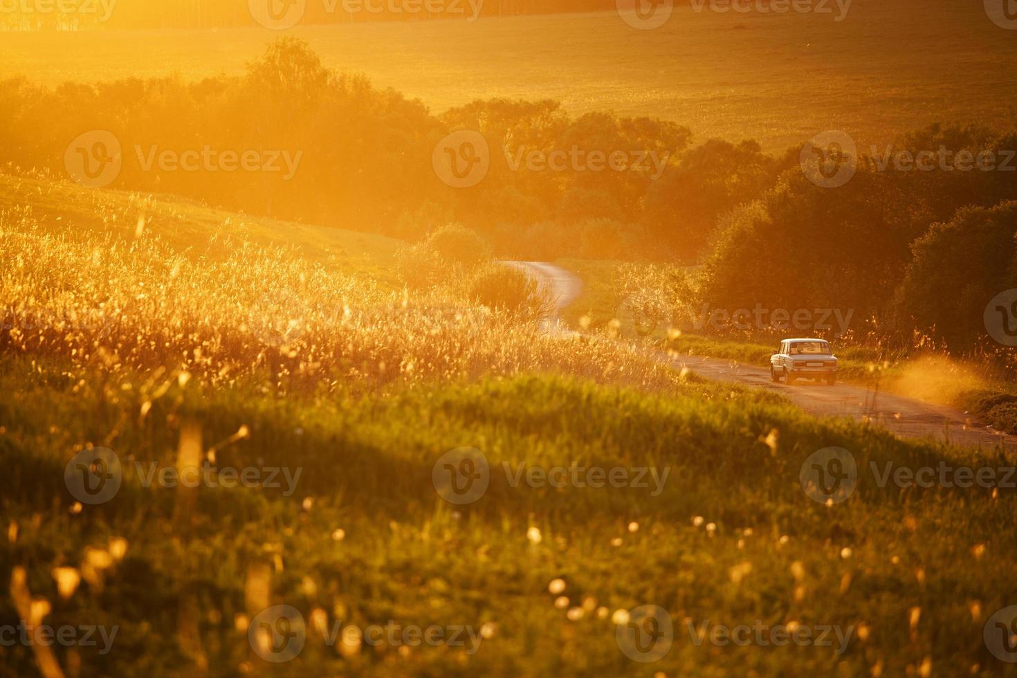 Auto auf einer Landstraße zwischen Feldern unterwegs foto