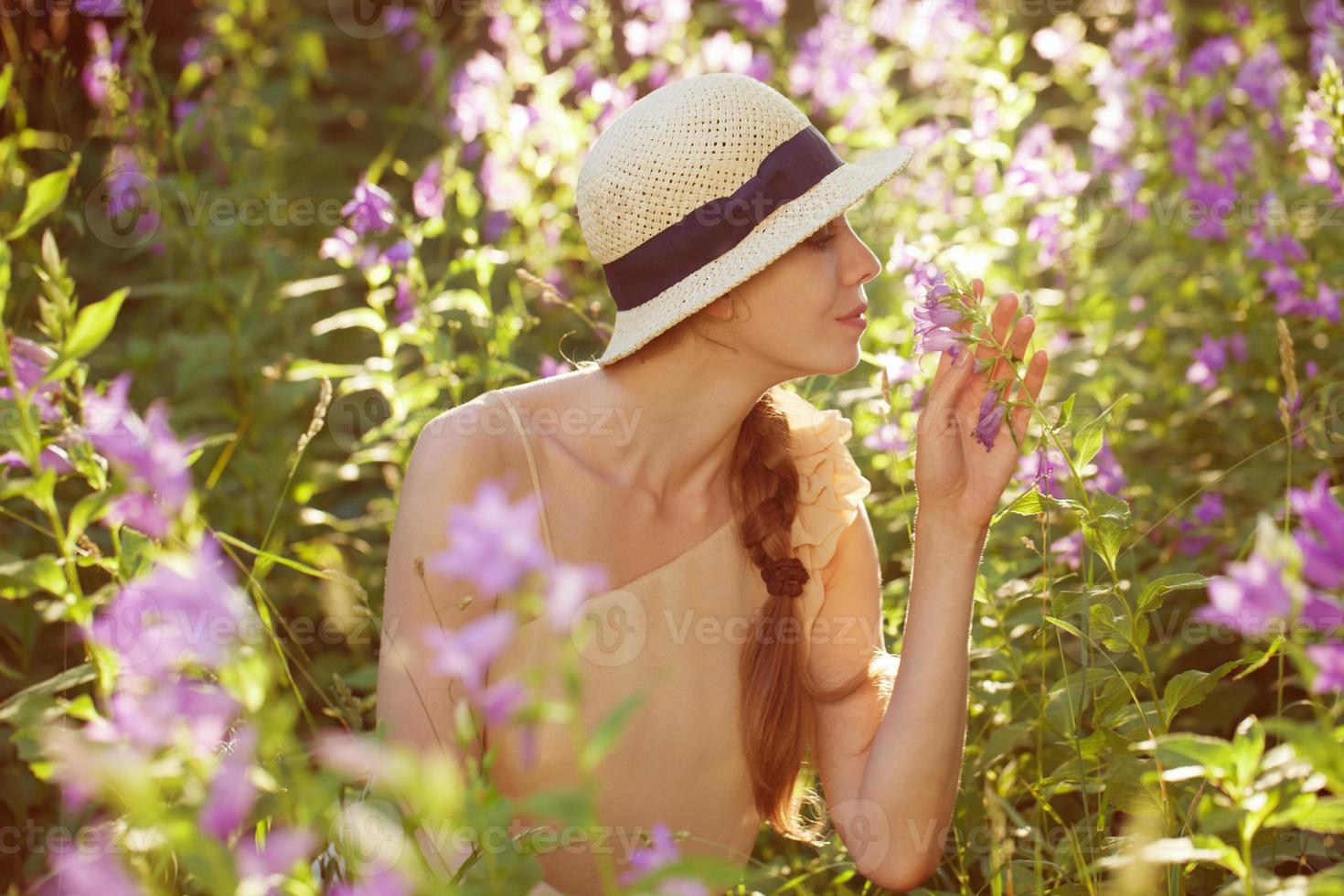 schöne Frau, die den Duft von Wildblumen genießt foto