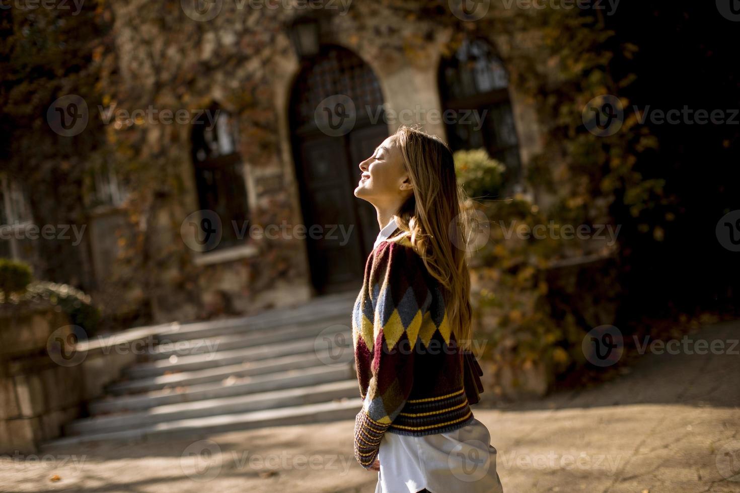 hübsche junge Frau, die im Herbstpark spazieren geht foto