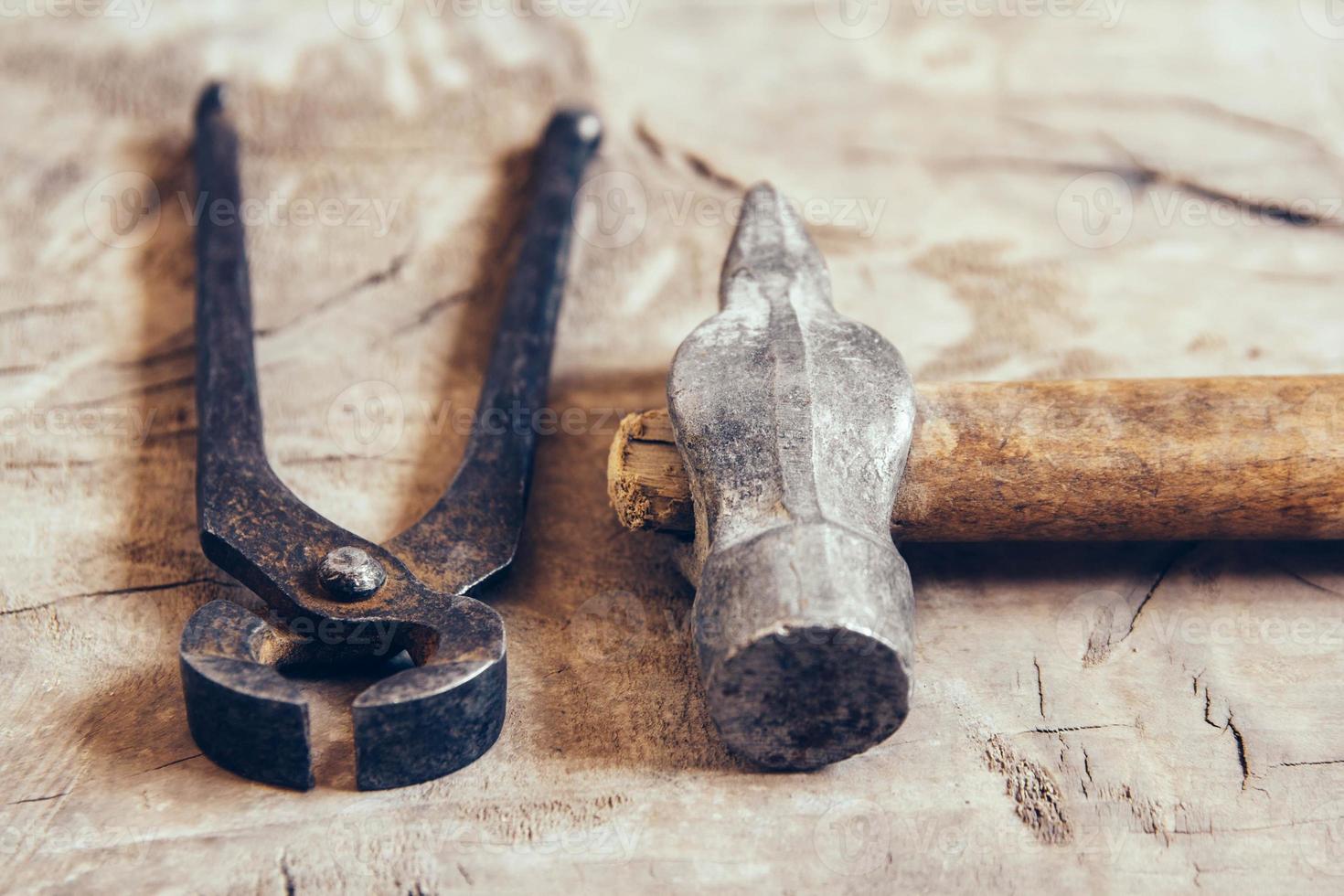 alte rostige Zangen und Hammer auf Holzuntergrund foto