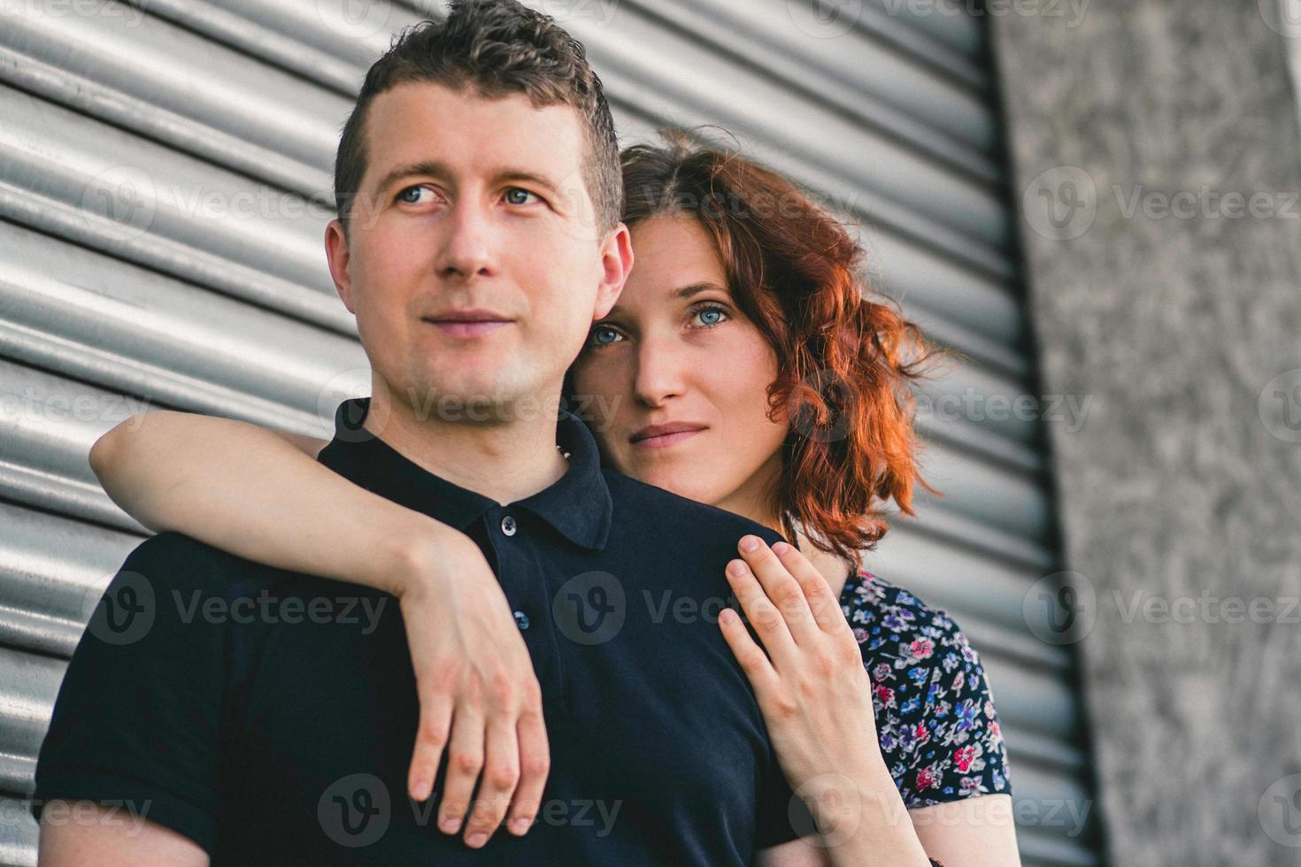 Mann und Frau umarmen sich auf dem Hintergrund der grauen Wände foto