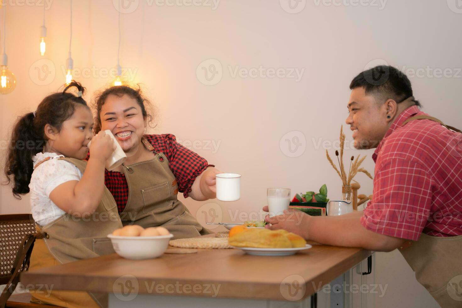 ein Übergröße Familie mit ein Vater tragen ein Prothese Bein, Essen zusammen nach Kochen und Tochter Getränke Milch zum Gesundheit im das Essen Zimmer von das Haus foto