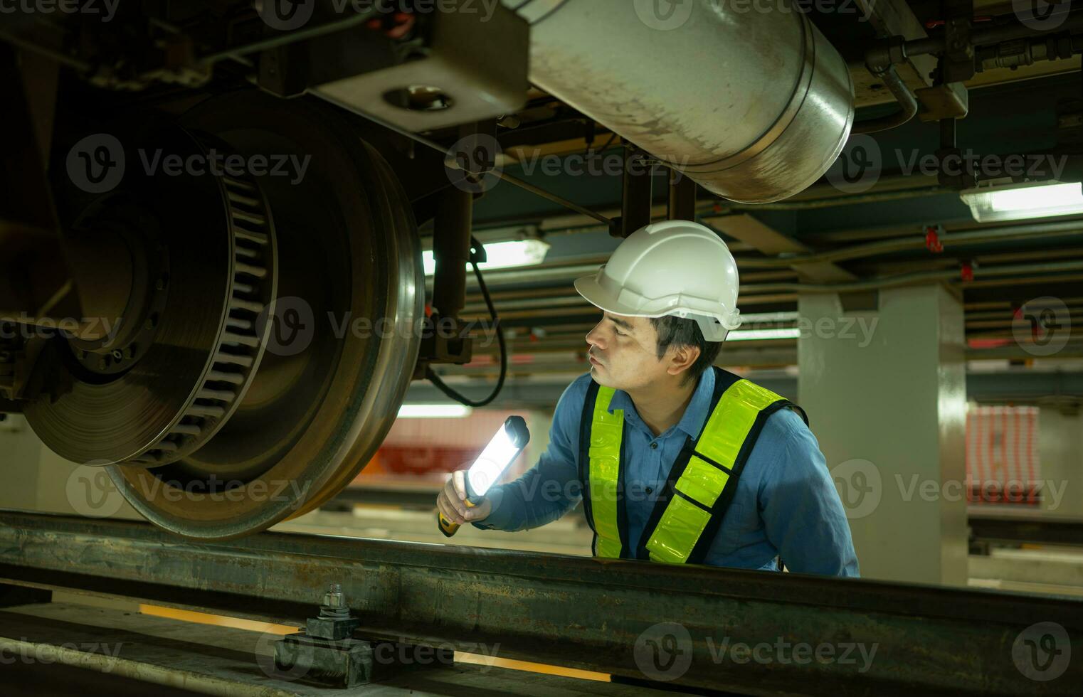 Ingenieure zum elektrisch Züge nach Erkennen Schwierigkeiten mit das elektrisch Züge Maschinen verwenden Suchscheinwerfer zu Lokalisieren und prüfen beschädigt Abschnitte. im das elektrisch Zug Reparatur Geschäft foto