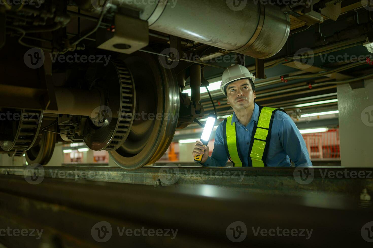 Ingenieure zum elektrisch Züge nach Erkennen Schwierigkeiten mit das elektrisch Züge Maschinen verwenden Suchscheinwerfer zu Lokalisieren und prüfen beschädigt Abschnitte. im das elektrisch Zug Reparatur Geschäft foto