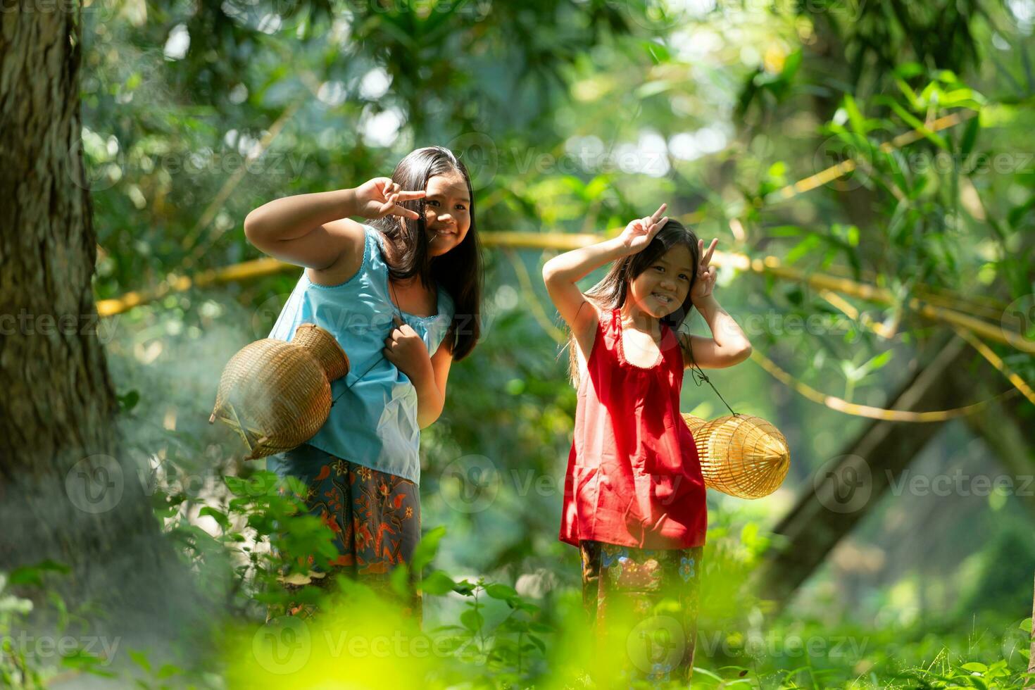 zwei Mädchen asiatisch Frauen mit traditionell Kleidung Stand im das Regenwald. Sie hätten Spaß spielen zusammen Vor assistieren Opa im fangen Fisch im ein in der Nähe See. foto