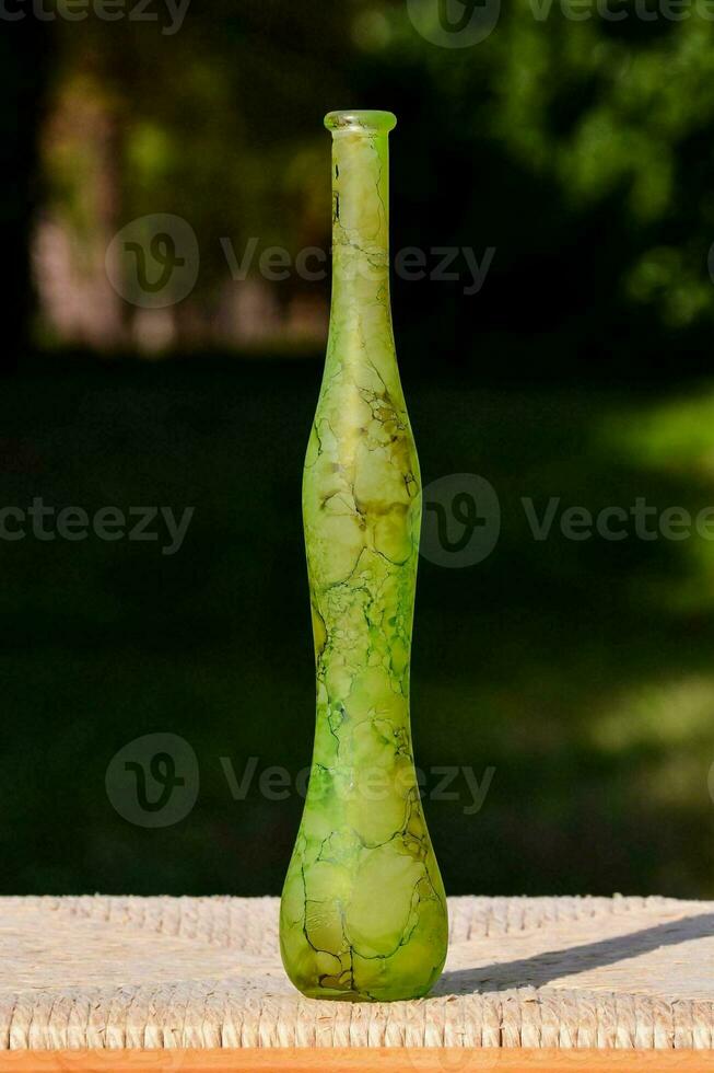 ein Grün Glas Vase Sitzung auf ein hölzern Tabelle foto