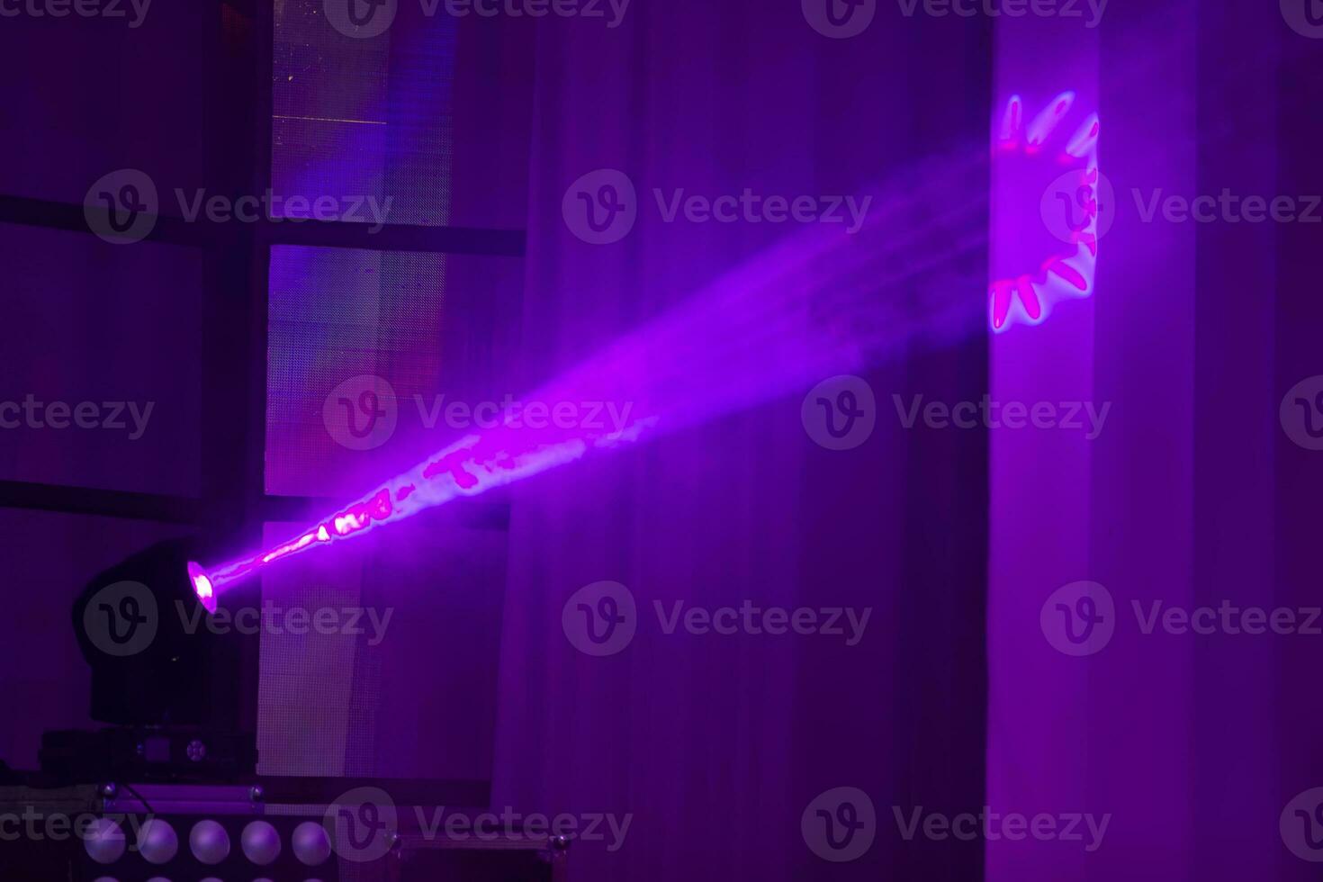 mehrfarbig Strahlen von Licht von ein Bühne Scheinwerfer auf ein Blau Hintergrund. foto