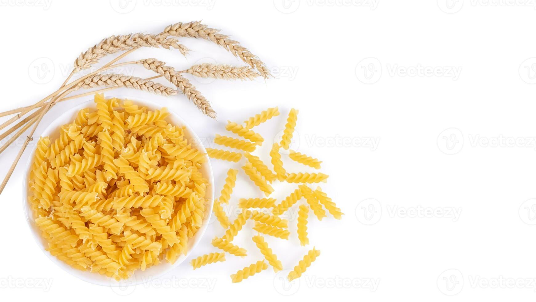 roh Pasta Fusilli im Schüssel und Weizen Ährchen isoliert auf Weiß Hintergrund foto