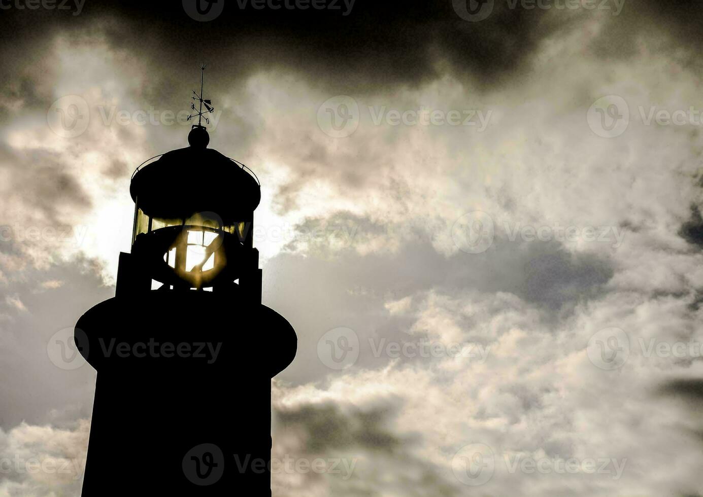 das Silhouette von ein Leuchtturm gegen das Wolken foto