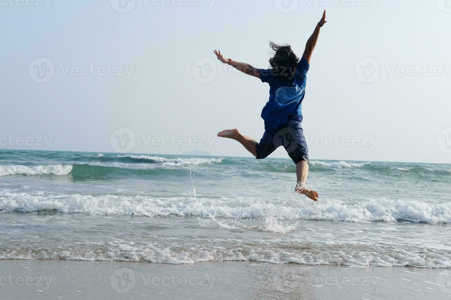 Glück von asiatisch Frau ist Springen auf Himmel mit Meer und Welle auf das Sand Strand im natürlich Sonnenuntergang. Freiheit einsam Leben auf Ferien foto