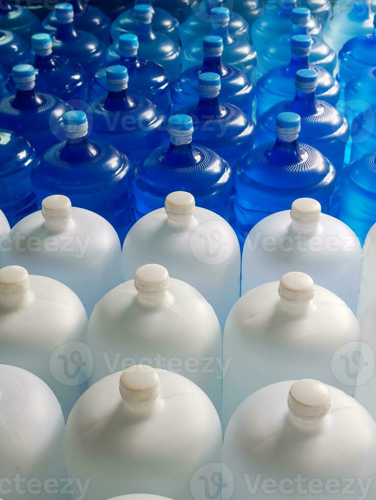 oben Aussicht von Plastik groß Flaschen oder Weiß und Blau Gallonen von gereinigt Trinken Wasser Innerhalb das Produktion Linie. Wasser trinken Fabrik foto