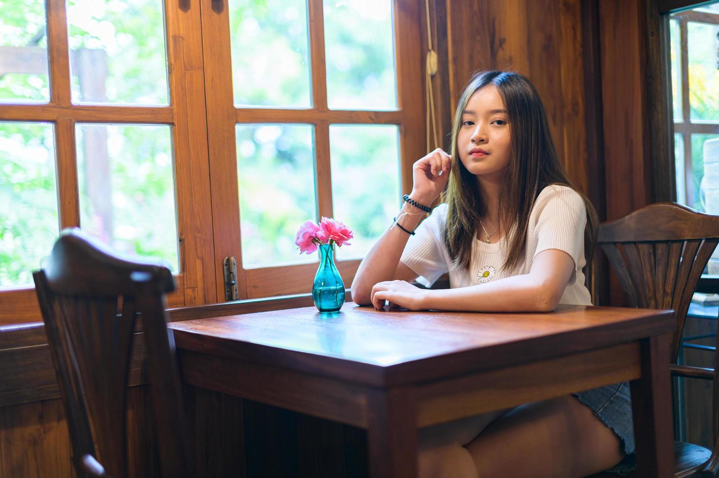 schöne Frau sitzt auf einem Stuhl in einem Café foto